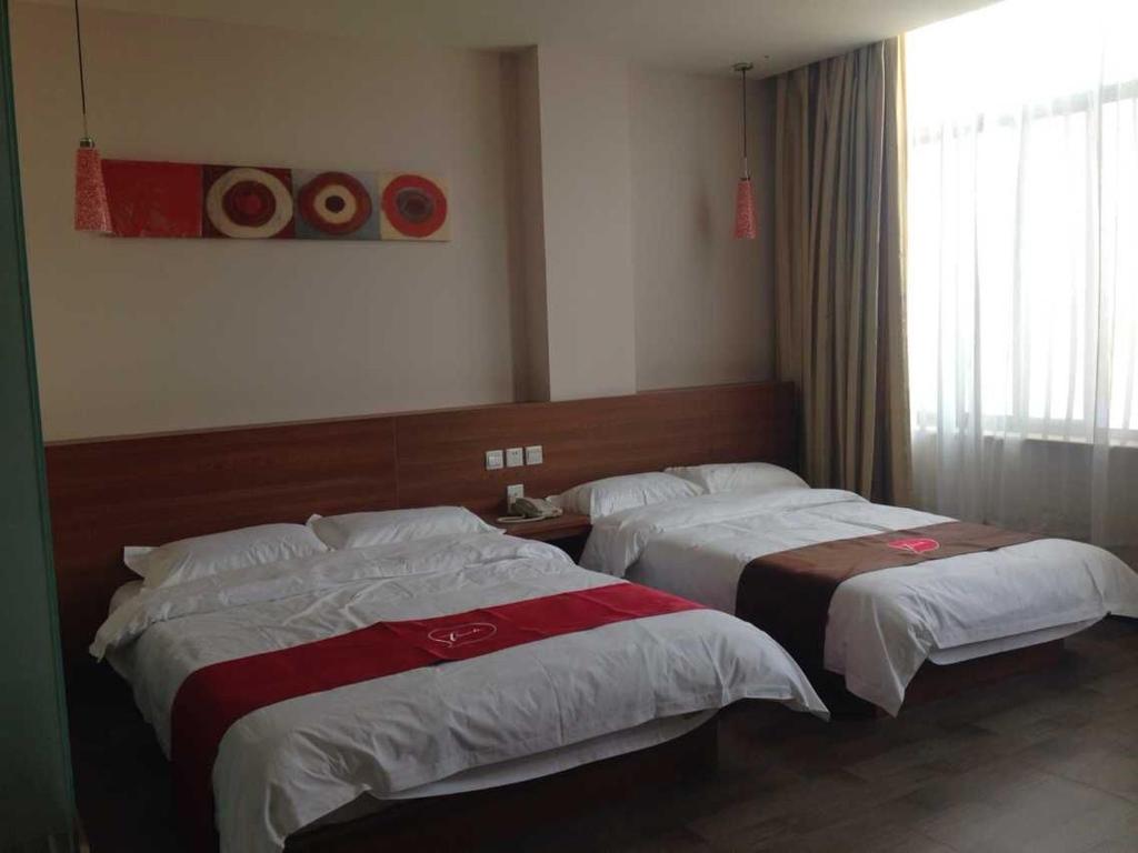 um quarto de hotel com duas camas e uma janela em Thank Inn Chain Hotel Hebei Shijiazhuang Luancheng Communication University em Mengdongzhuang