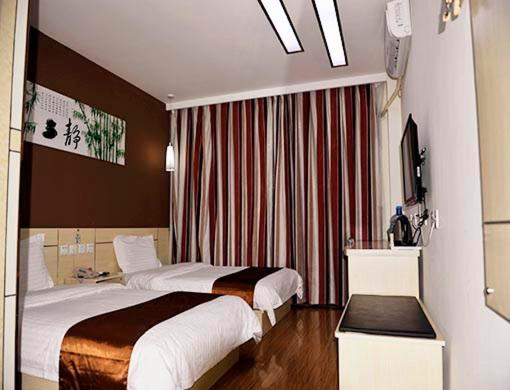 a hotel room with two beds and a window at Thank Inn Chain Hotel Shandong Dezhou Ningjin Zhengyang Road Xinhua Building in Ningjin