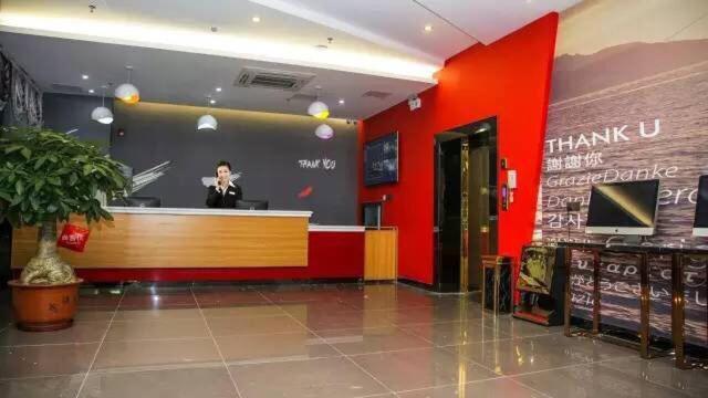 a woman standing behind a counter in a store at Thank Inn Chain Hotel Guangdong Shanwei Haifeng County Erhuan Dongnanqiao in Shanwei