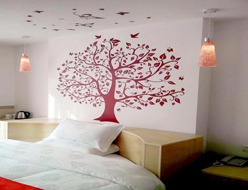 a bedroom with a tree with birds on the wall at Thank Inn Chain Hotel Guangdong Heyuan East Longchuang Road in Longchuan