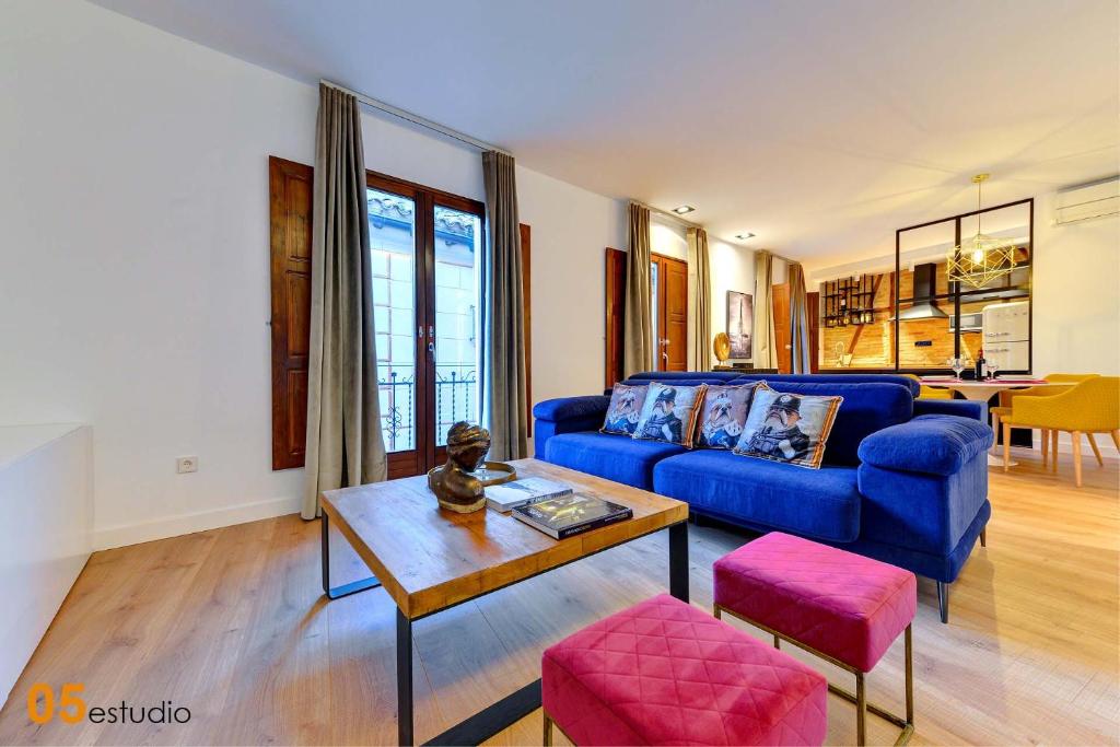 a living room with a blue couch and a table at Azotea de la Catedral in Toledo