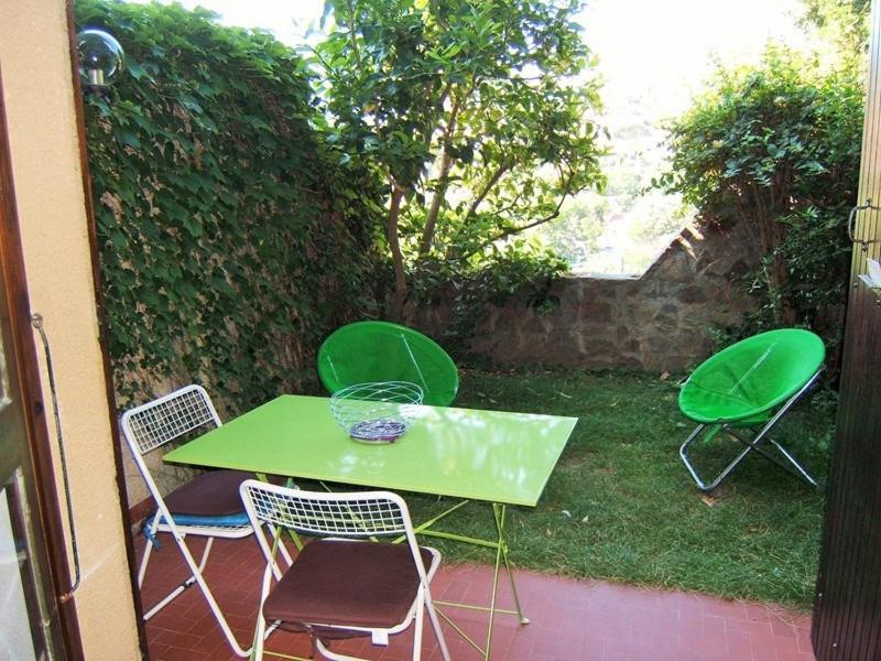 uma mesa verde e cadeiras num pátio em 3CPF29 Appartement avec jardinet et parking, proche centre-ville em Collioure