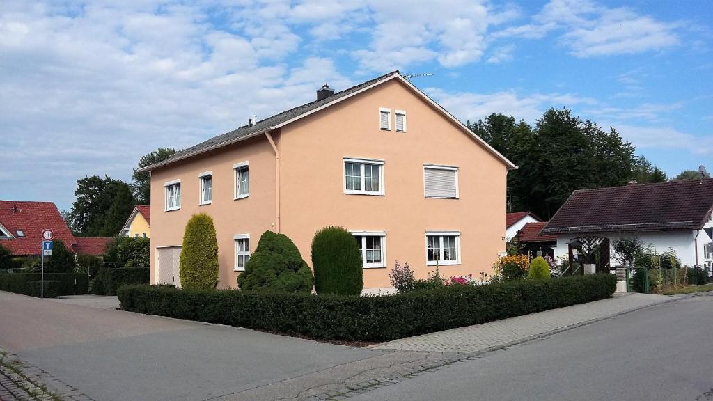 a pink house with bushes in front of a street at Appartementhaus Scholz in Egglfing