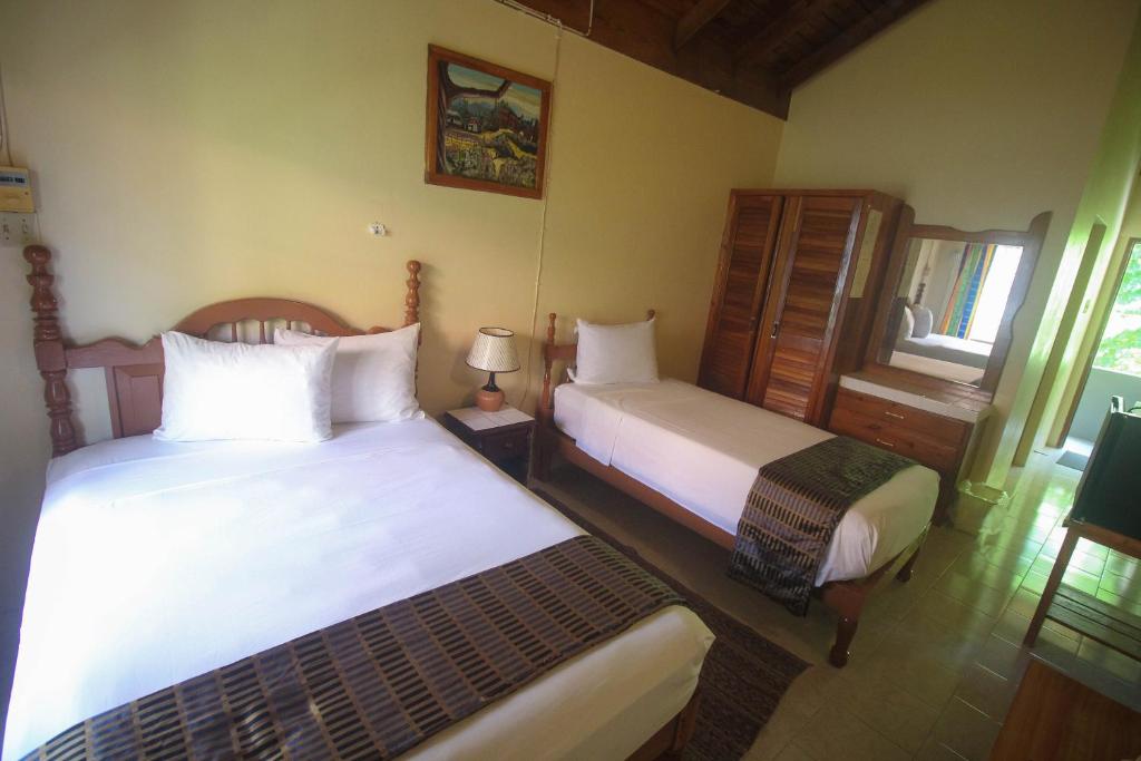 a bedroom with two beds and a window at Moonrisevillas in Negril