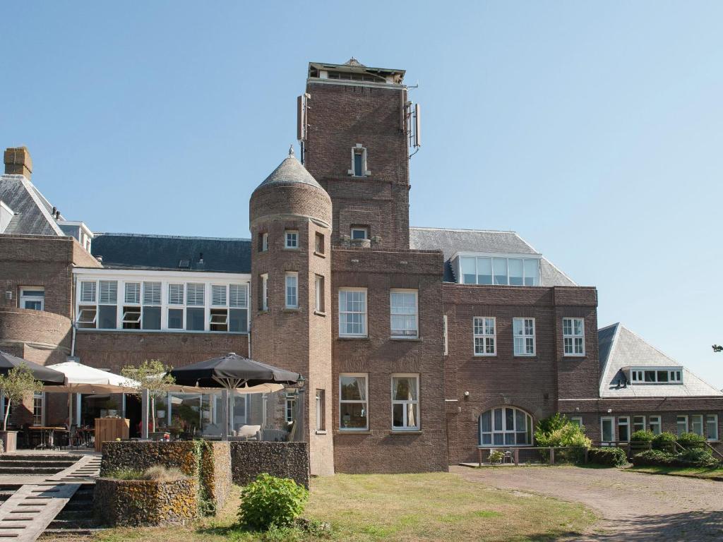 ベルゲン・アーン・ゼーにあるModern apartment near the seabeachの塔のある大きなレンガ造りの建物