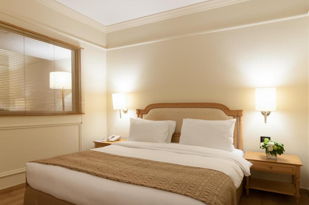 Postel nebo postele na pokoji v ubytování Le Commodore Hotel