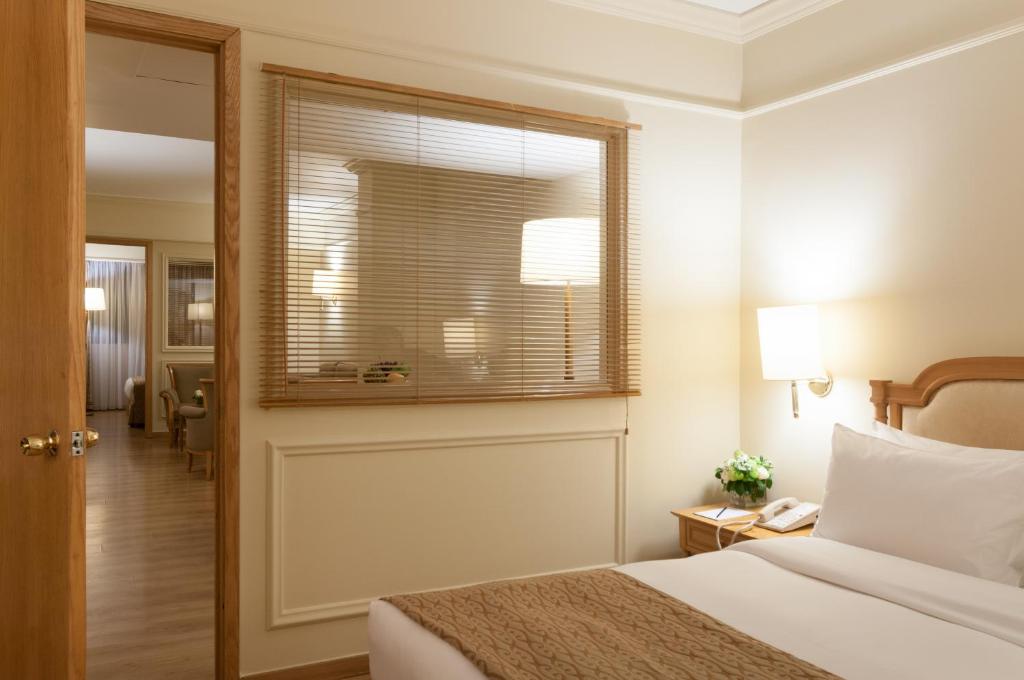 Postel nebo postele na pokoji v ubytování Le Commodore Hotel