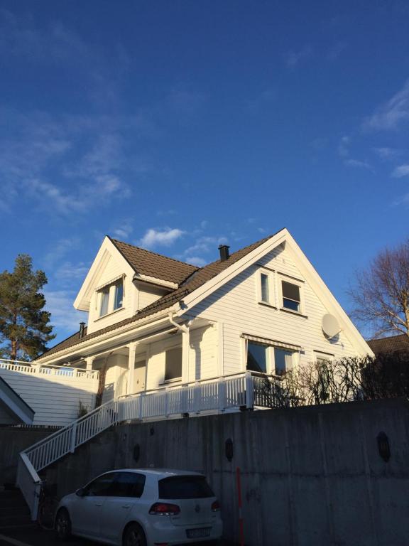 een witte auto geparkeerd voor een huis bij Idyllisk sørlandshus in Risør