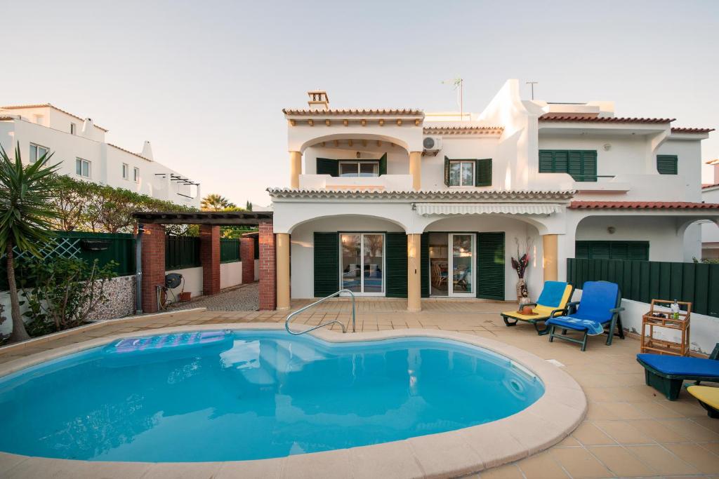a swimming pool in front of a house at Sunflower Villa - Blue Sea in Albufeira