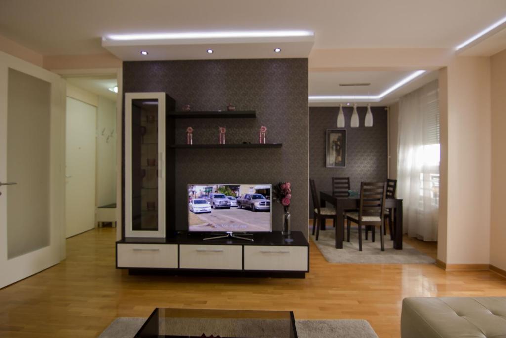 ein Wohnzimmer mit einem TV und einem Esszimmer in der Unterkunft Belville Superior in Belgrad
