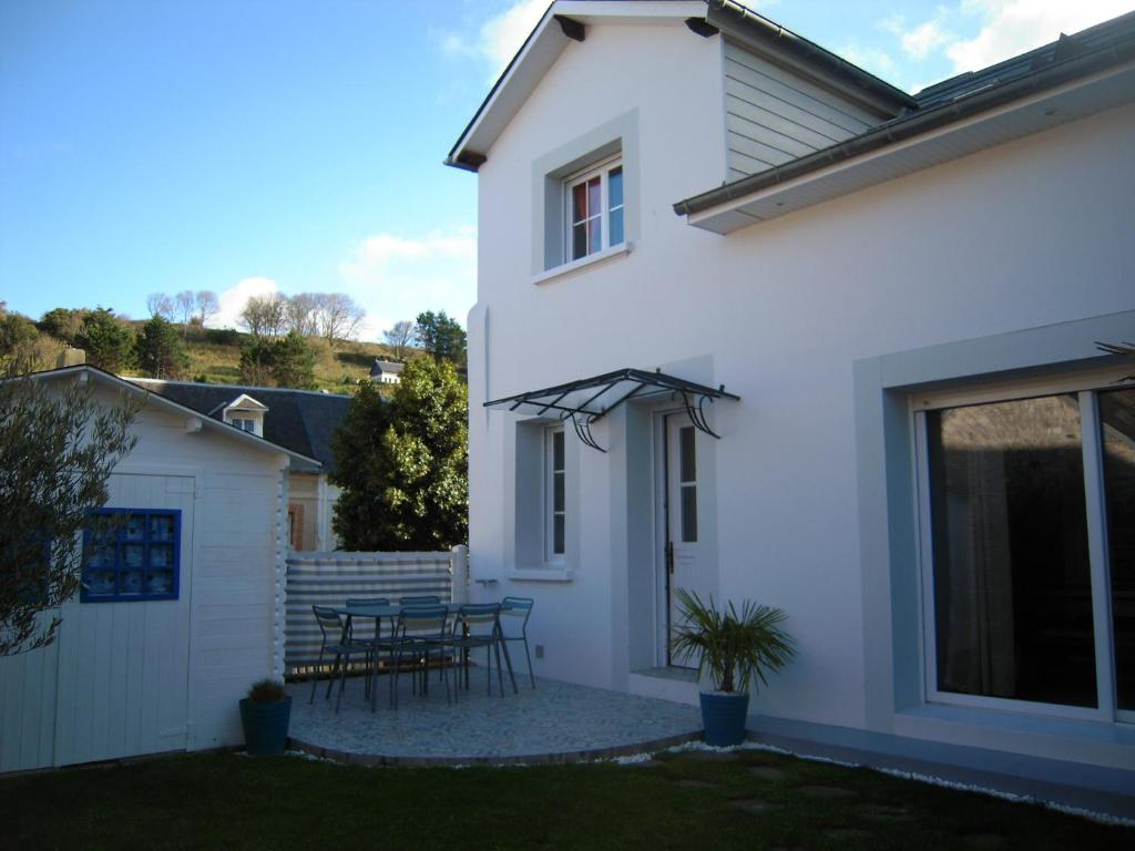 Dieses weiße Haus verfügt über eine Terrasse mit einem Tisch. in der Unterkunft Chez Fanou in Yport
