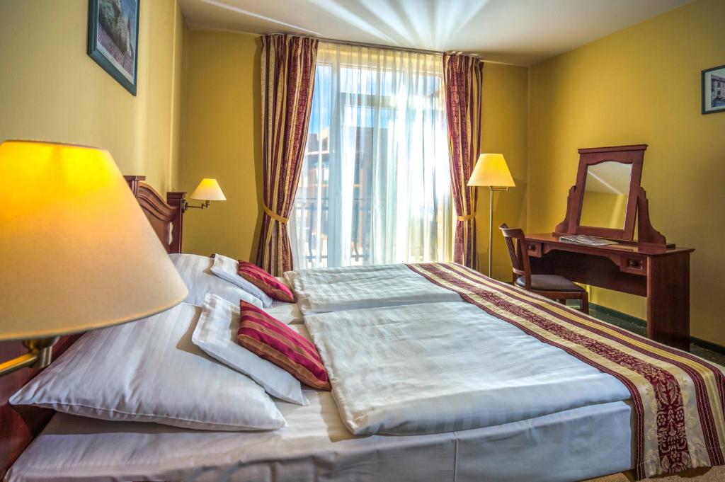 Postel nebo postele na pokoji v ubytování Hotel Kapitany Wellness