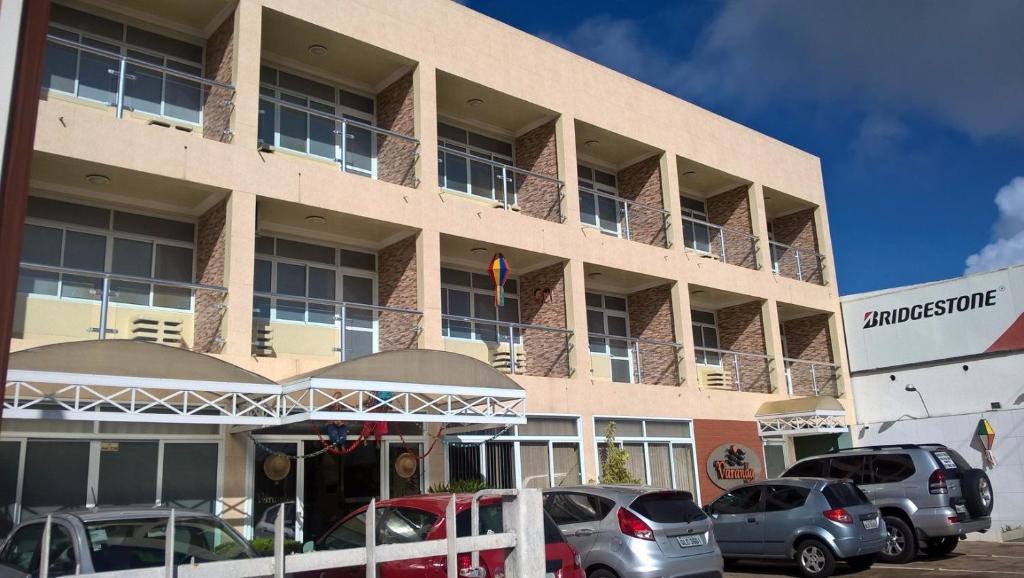 un edificio con coches estacionados frente a él en Varanda Hotel, en Arapiraca