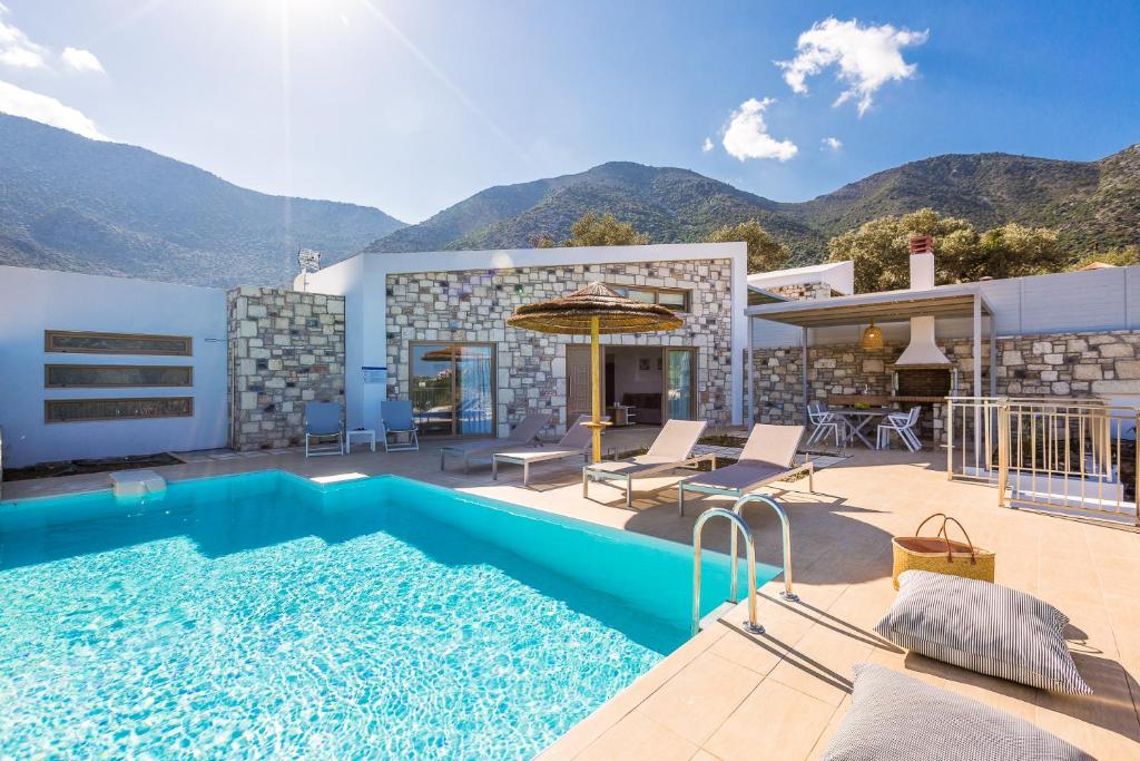 a villa with a swimming pool and mountains in the background at Summer Villas Crete in Balíon
