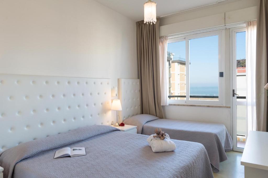Postel nebo postele na pokoji v ubytování Hotel La Perla Rimini