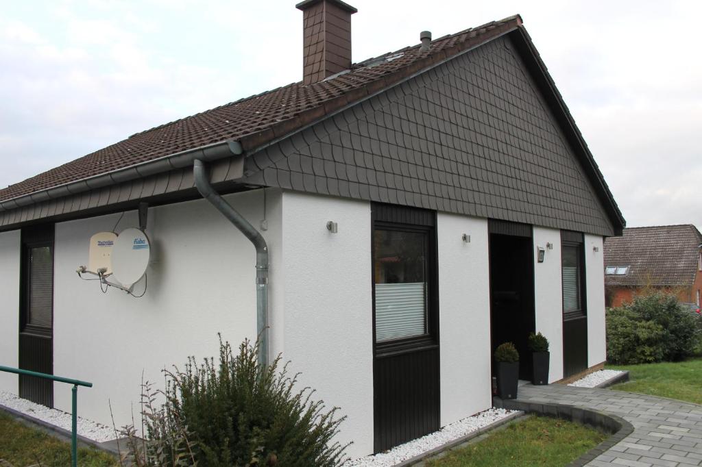 una casa blanca y negra con techo negro en Ferienhaus Sommerfeld, en Hameln