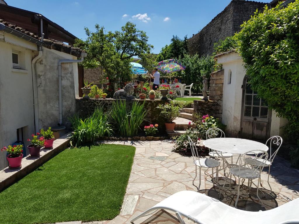 een patio met een tafel en stoelen in een tuin bij TOURNUS Belle maison vue sur Saône in Tournus