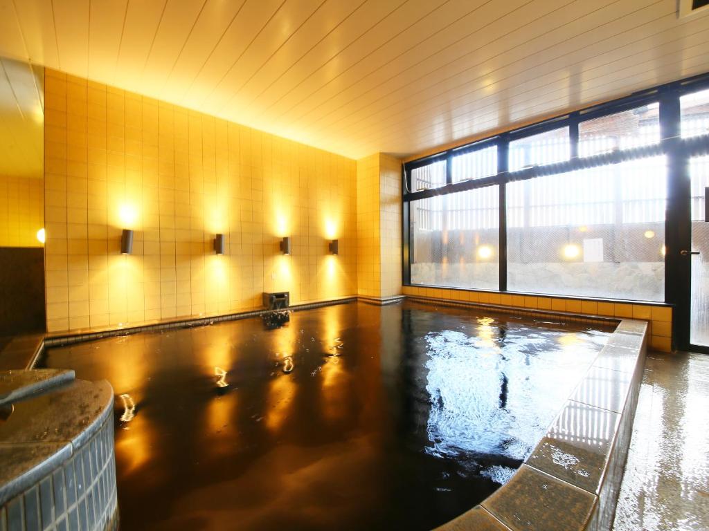 a swimming pool in a room with a large window at APA Hotel Chiba Yachiyo Midorigaoka in Yachiyo