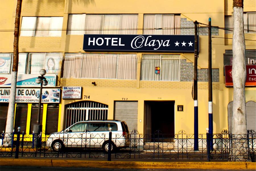 une voiture blanche garée devant un clova d'hôtel dans l'établissement Hotel Olaya, à Lima