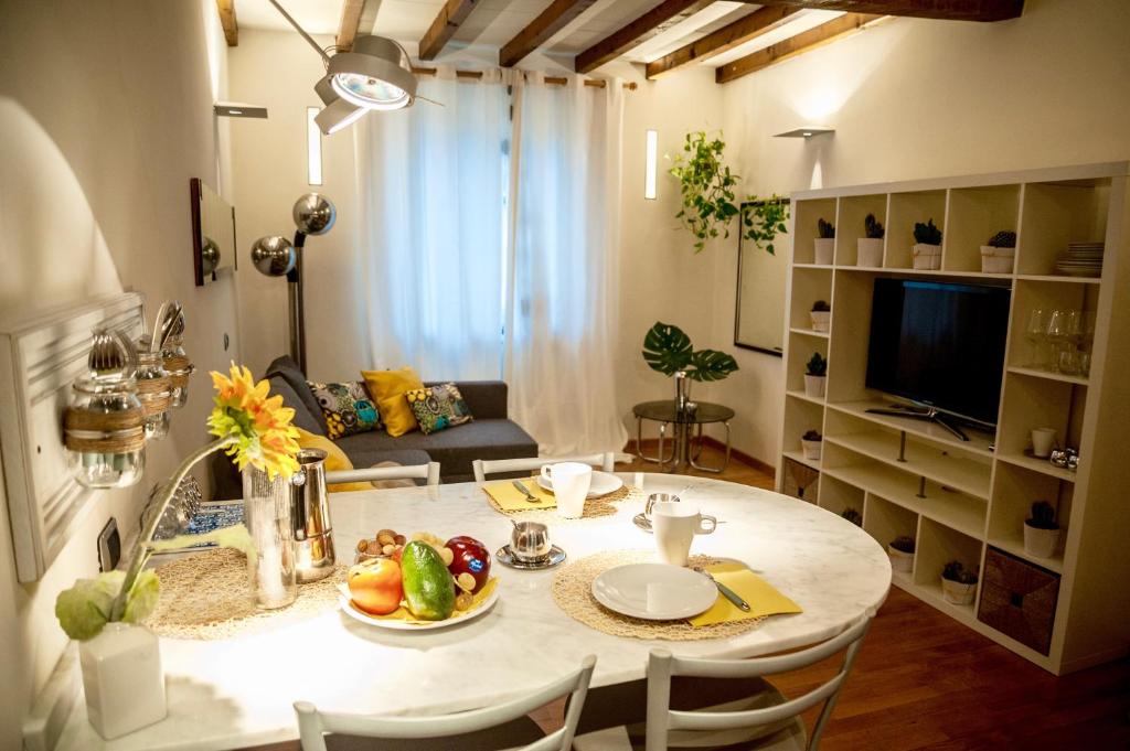 BDC_38Apartment في بارما: مطبخ وغرفة معيشة مع طاولة عليها فاكهة