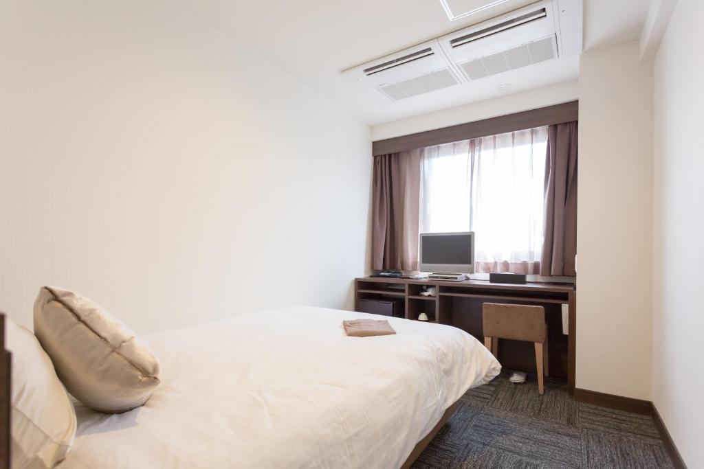 Postel nebo postele na pokoji v ubytování Shimizu City Hotel