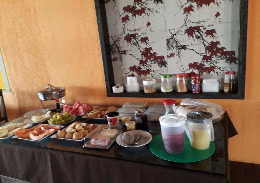 a table with a buffet of food and drinks at Recanto do Mergulhão in Maceió