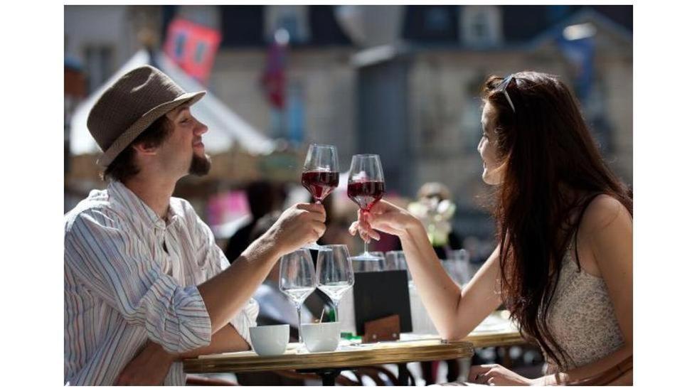LuzyにあるPetit sejour aux portes du Morvanのワインを飲むテーブルに座る男女