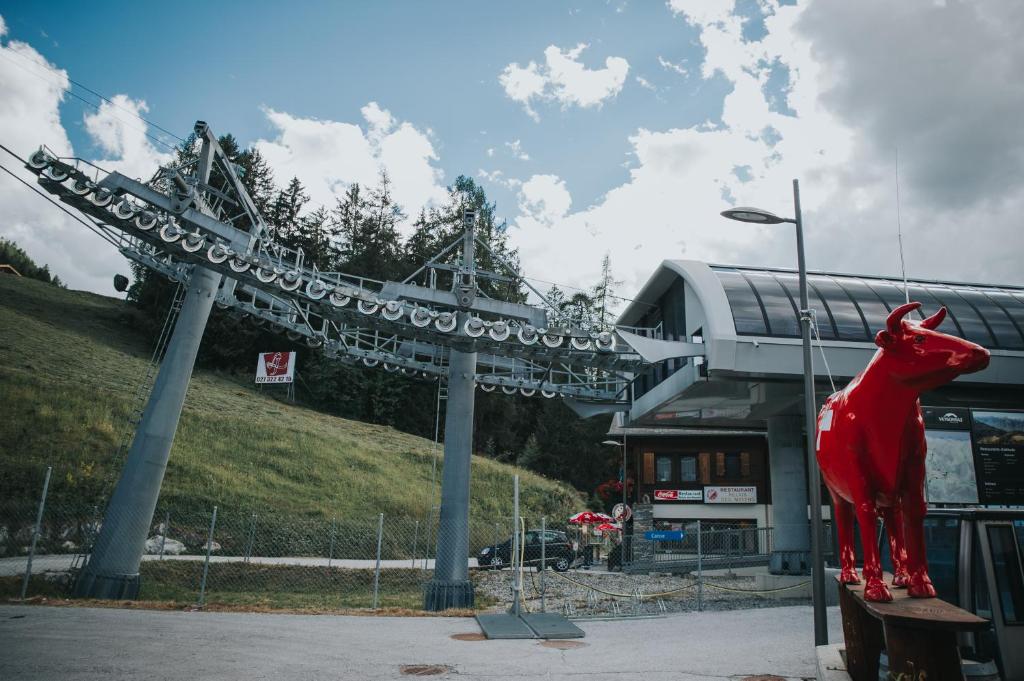 a red cow statue in front of a building at Hôtel Magrappé in Veysonnaz