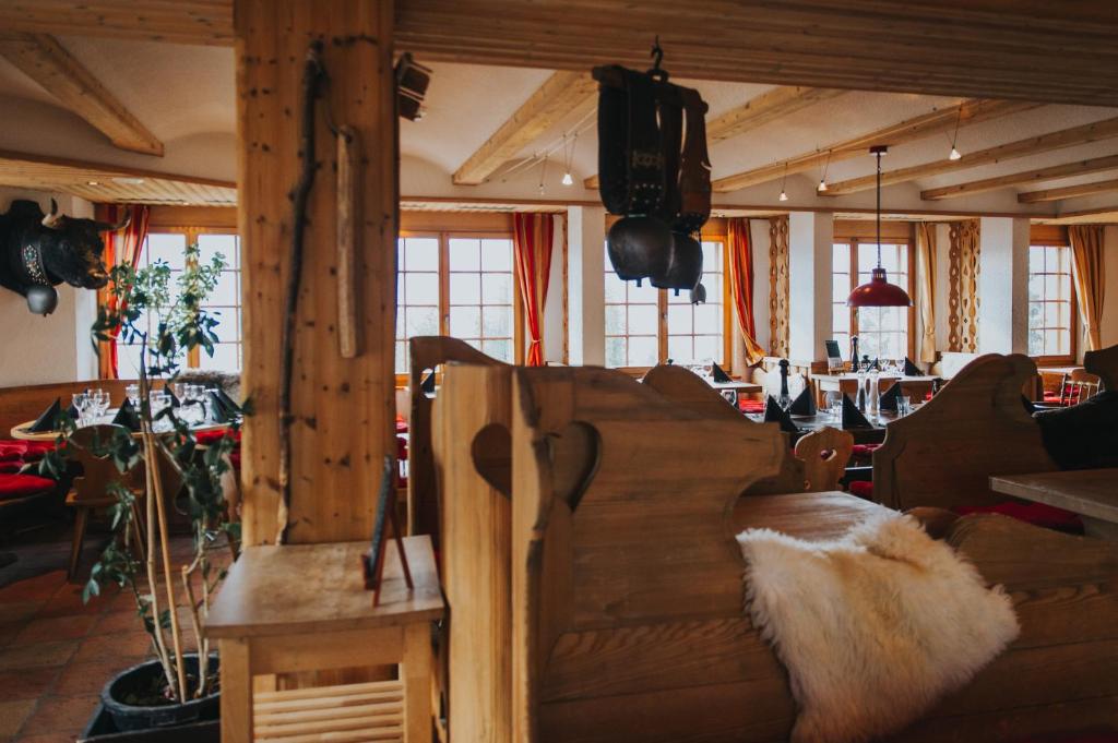 a living room with a couch and a table and windows at Hôtel Magrappé in Veysonnaz