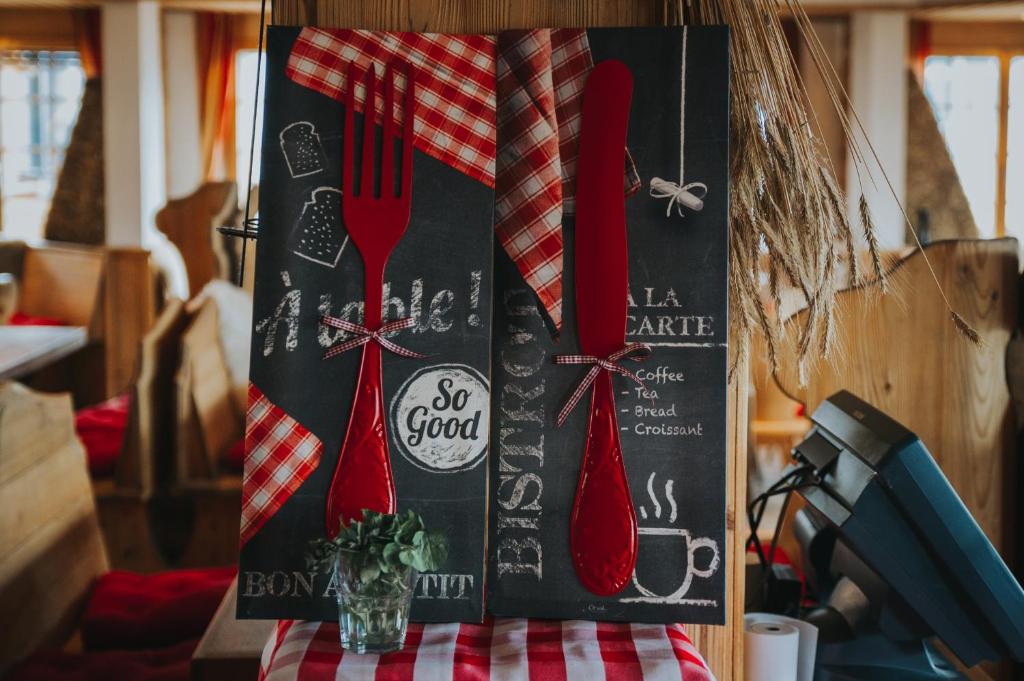 a black board with red utensils on a table at Hôtel Magrappé in Veysonnaz