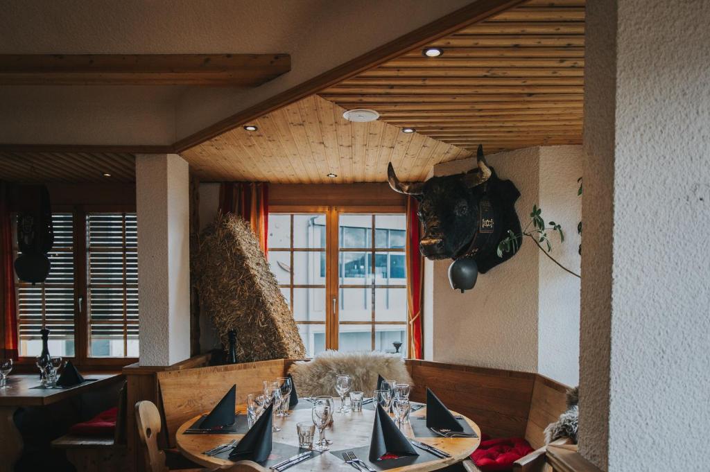a dining room with a table and a window at Hôtel Magrappé in Veysonnaz