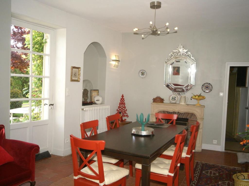 a dining room with a table and chairs and a mirror at Apartment with south facing balcony in Yèvre-le-Châtel