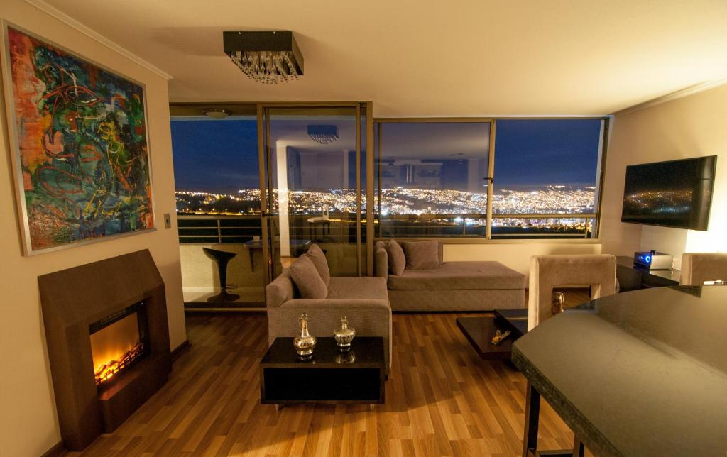 a living room with a fireplace and a view of a city at Viña Town House in Viña del Mar
