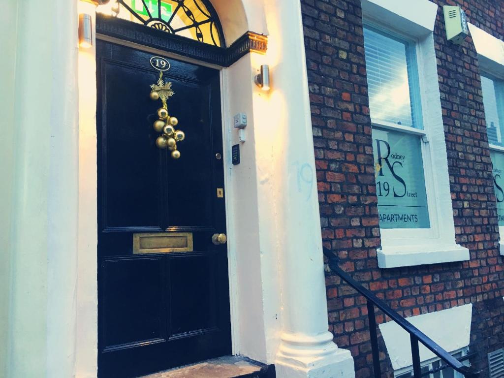 uma porta preta no lado de um edifício de tijolos em 19 Rodney Street Apartments em Liverpool