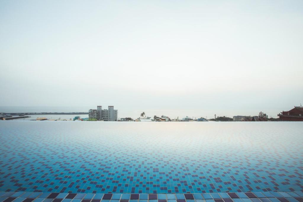 ein Pool mit blauen Fliesen auf dem Wasser in der Unterkunft FangLiao Hotel in Fang-liao