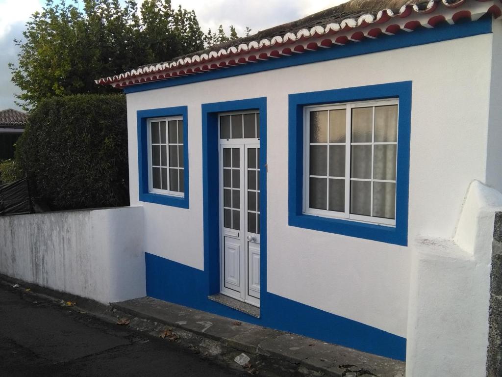 ポンタ・デルガダにあるCasa da Ladeiraの青いドアと窓のある小さな家