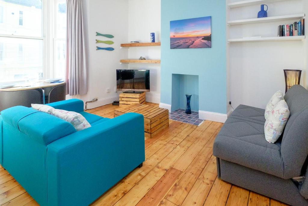 a living room with a blue couch and a chair at Central Garden Apartment in Brighton & Hove