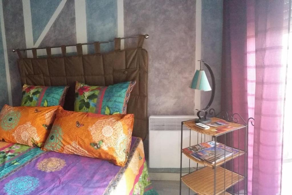 1 dormitorio con 1 cama y 1 mesa con lámpara en chambre chez l'habitant en Céret