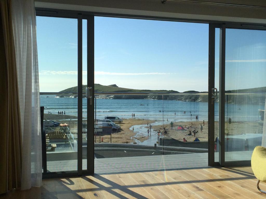 a view of a beach from a room with sliding glass doors at 9 Sandpiper Cottages in Newquay