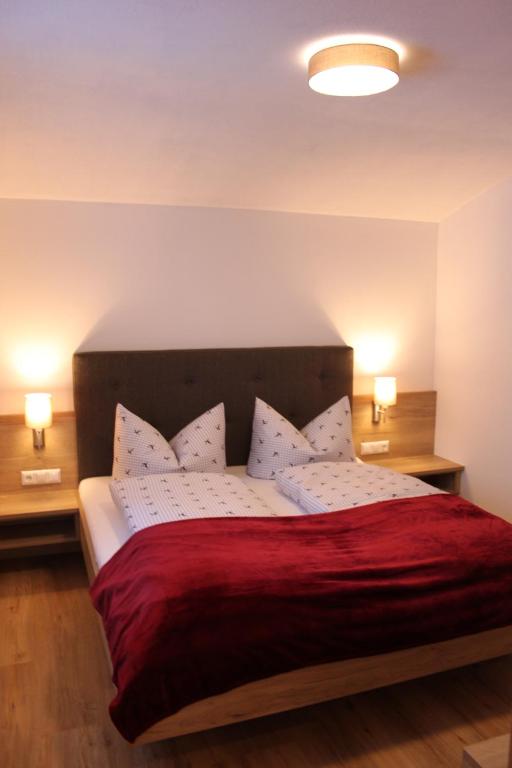 una camera da letto con un grande letto con una coperta rossa di Hinterschwarzenau ad Auffach