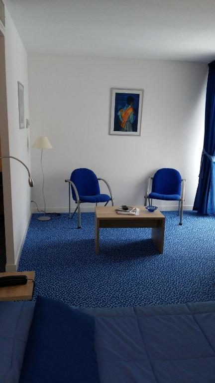 a room with two blue chairs and a table at Les Balcons Du Velay in Monistrol-sur-Loire