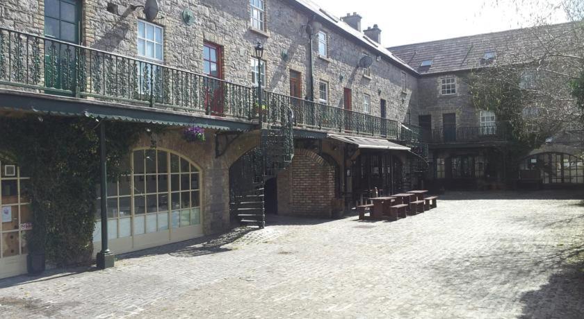 a courtyard of a building with a balcony and a bench at Boutique Apartment Ballina Town Centre in Ballina