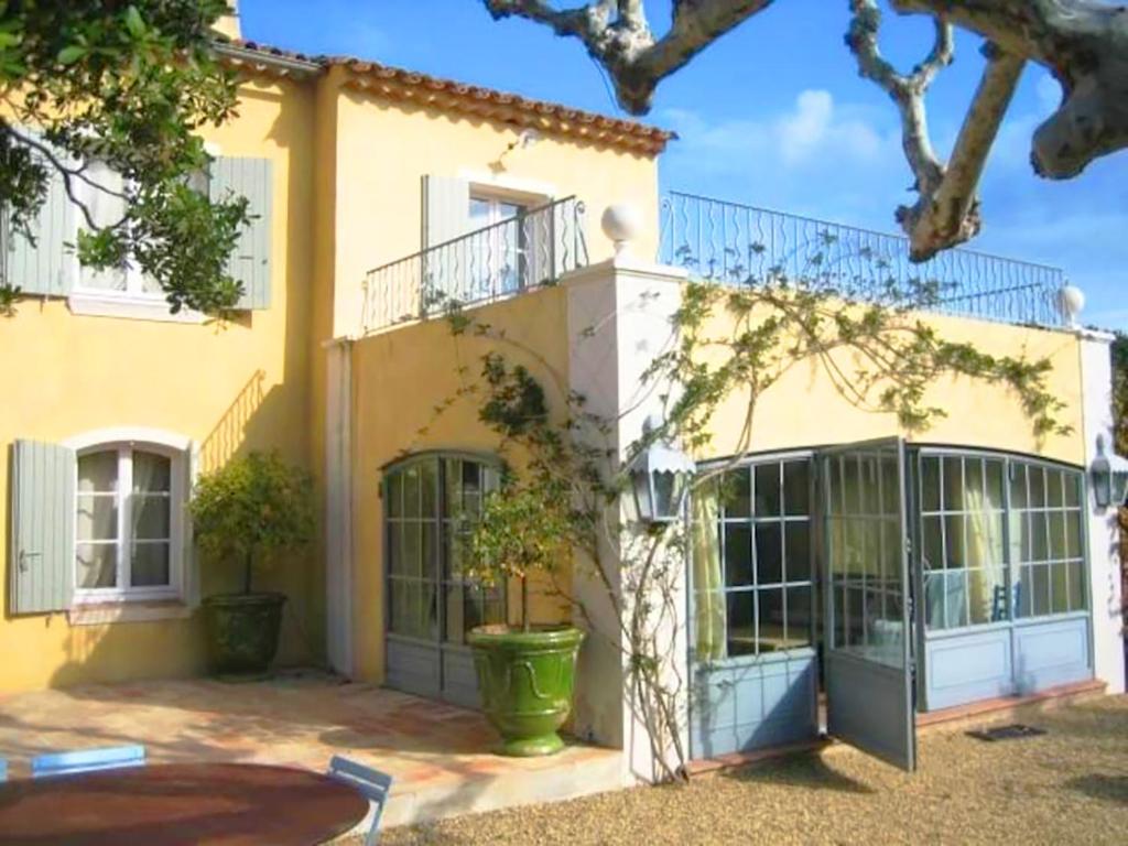 Casa amarilla grande con ventanas grandes y patio. en Villa Virginie, en Saint-Tropez