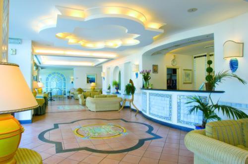 eine Lobby mit Sofas und Stühlen sowie eine Lobby in der Unterkunft Hotel Club Sabbiadoro in Battipaglia