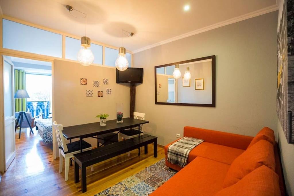 uma sala de estar com um sofá laranja e uma mesa em Ola Lisbon -Alfama I em Lisboa