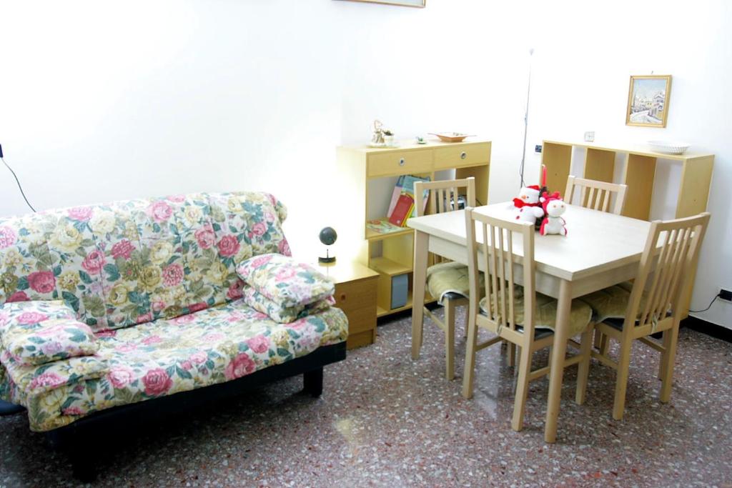 ein Wohnzimmer mit einem Sofa, einem Tisch und einem Stuhl in der Unterkunft Relax e mare in Savona
