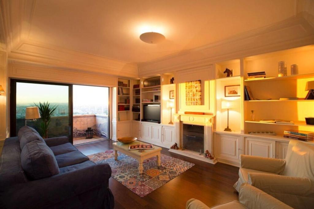 - un salon avec un canapé et une cheminée dans l'établissement Ola Lisbon -Areeiro, à Lisbonne