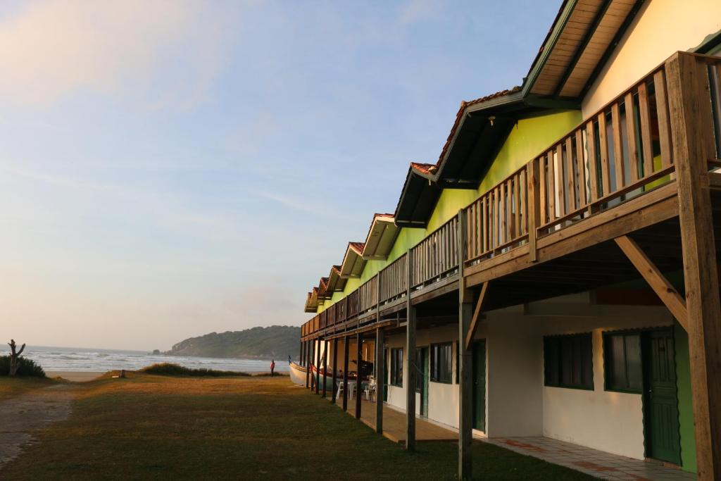 a building on the beach with the ocean in the background at Pousada do Luz in Imbituba