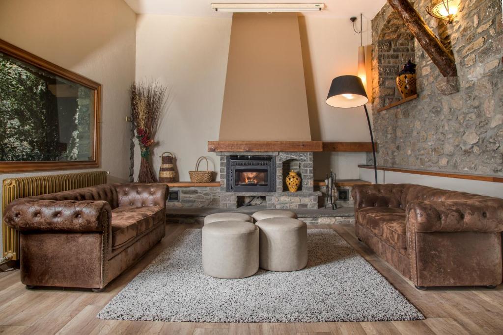 a living room with two couches and a fireplace at Hotel Roca in Alp