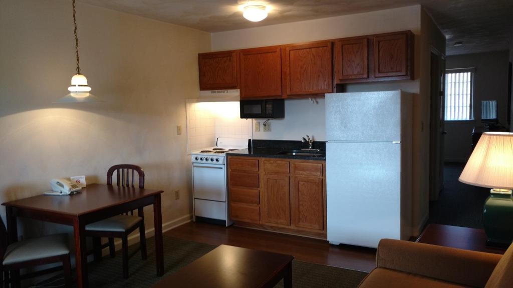 a kitchen with a white refrigerator and a table at Affordable Suites Charlottesville in Charlottesville